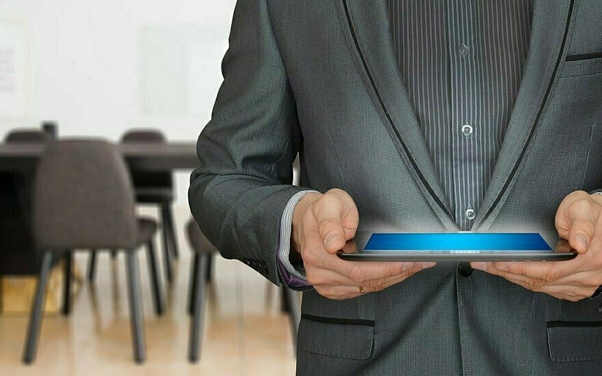 Ein Mann mit Tablet in der Hand bei einer Tagung Ein Mann mit Tablet in der Hand bei einer Tagung